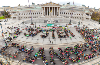 Demonstration von System Change, not Climate Change in Wien während der Klimakonferenz COP21. Aktivist*innen formen die Worte "System Change".